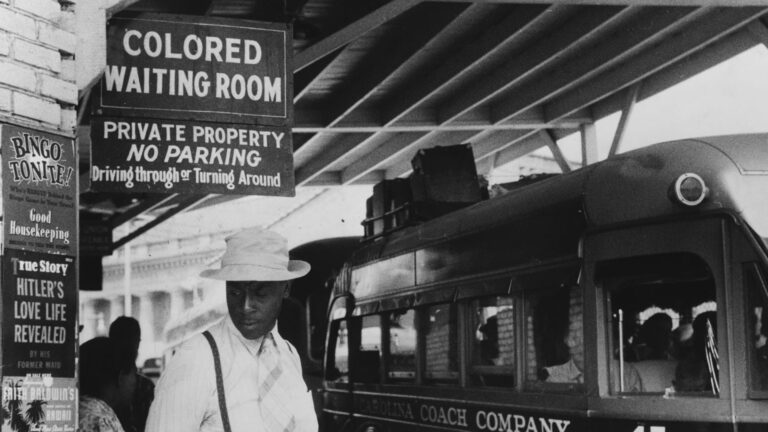 Person waiting below a "Colored Waiting Room" sign