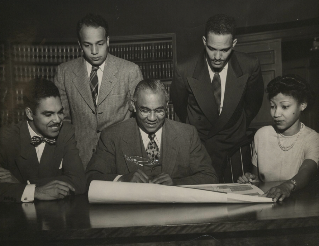 Dr. Albert Turner and colleagues reviewing building plans
